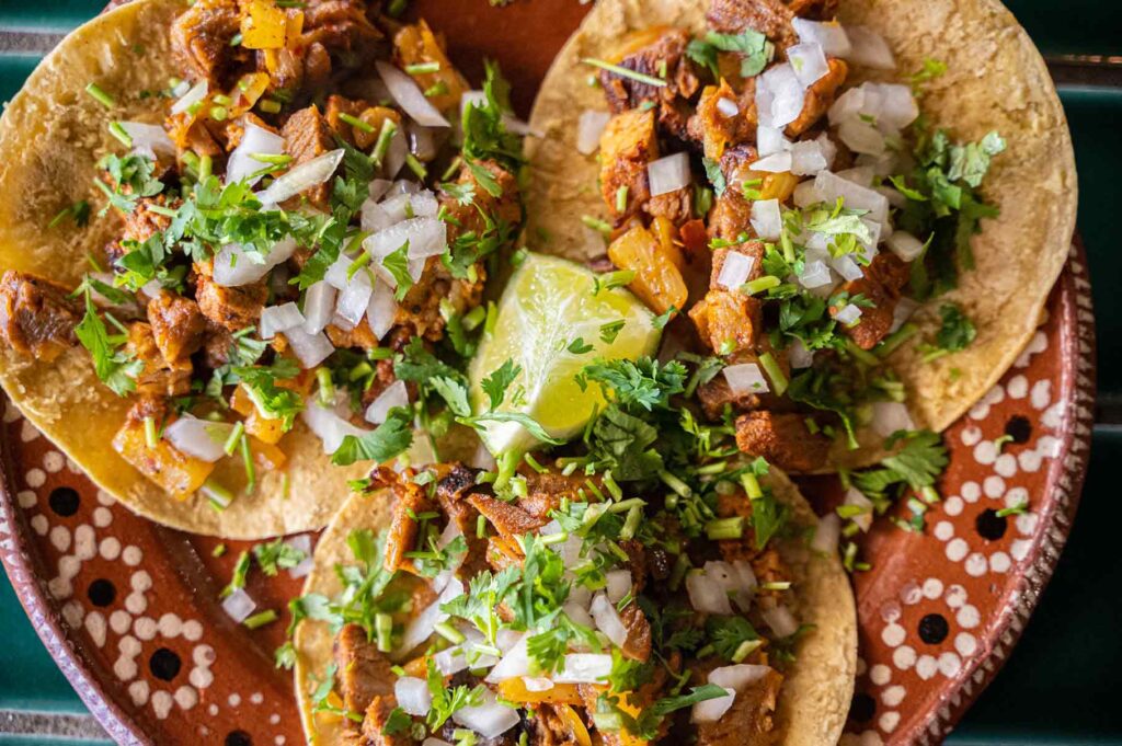 Tacos al pastor with onion and lime