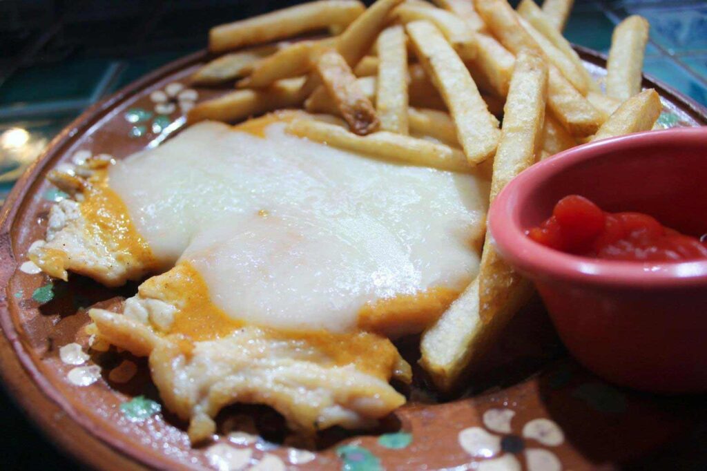 Grilled chicken with melted cheese on top, french fries and ketchup